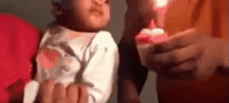 Baby blow out the candle with his hand