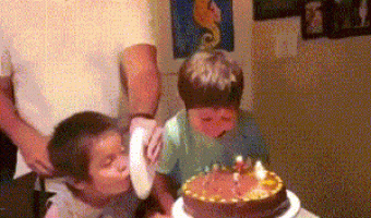 Dad and sons blowing out the candle on birthday