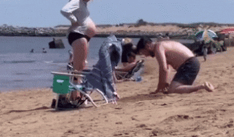Guy dug a hole in the sand for his pregnant partner